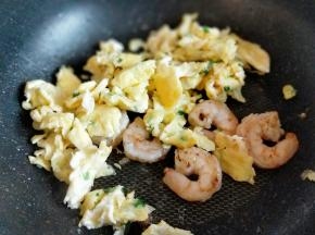 虾仁炒至变色后加入煎好鸡蛋，快速翻炒，关火盛出。