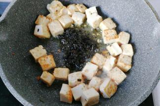 然后把豆腐块拨开，加入两勺橄榄菜；