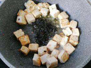 然后把豆腐块拨开，加入两勺橄榄菜；