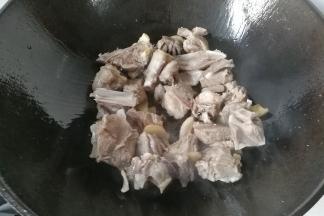 再下入羊肉，调入少许料酒和盐翻炒一会，炒至羊肉变色肉质收紧即可；