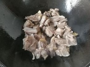 再下入羊肉，调入少许料酒和盐翻炒一会，炒至羊肉变色肉质收紧即可；