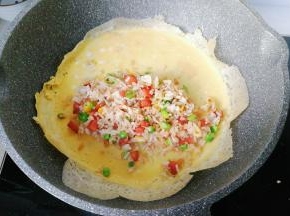 再把炒花的米饭摆在蛋皮上；