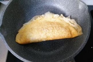 然后对折起来，用锅铲把蛋皮周围轻轻按压沾合起来，再盛入盘中；