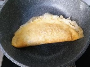 然后对折起来，用锅铲把蛋皮周围轻轻按压沾合起来，再盛入盘中；