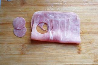 方形火腿片对折，用合适的模具刻出两个小圆片，即猫咪的小脸蛋儿；