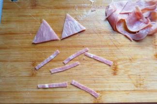 再用刀切出两份三角形和六条细条，即是猫咪的耳朵和胡须了；
