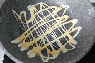 不沾锅用厨房纸巾先薄薄的抹成油，然后将瓶子中的蛋液挤出镂空状，小火煎至蛋液凝固即可；