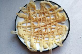 再将煎好的镂空蛋饼盛入盘子中，每两张一组叠放起来；