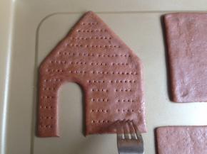 用叉子在饼干坯上叉出若干个小孔，以防在烘烤中变形，刷上蛋水液，松驰15分钟左右