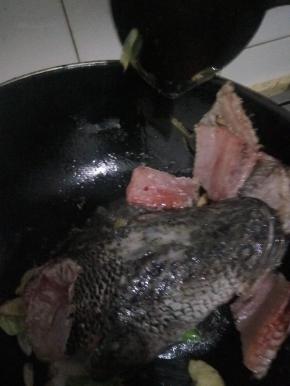 放入鱼头鱼骨和鱼尾爆油