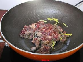 热锅，放油、生姜，倒入腌制好的牛肉；