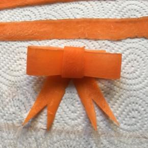 胡萝卜做成蝴蝶结形状，用意面固定好
