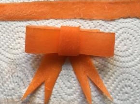 胡萝卜做成蝴蝶结形状，用意面固定好