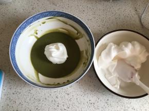 把蛋白霜平均分为两份，其中一份取1/3的蛋白霜到抹茶糊中，用刮刀J字形上下翻拌均匀，然后再分两次把剩余的蛋白霜加入到抹茶糊中，每次都要翻拌均匀后再加入蛋白霜