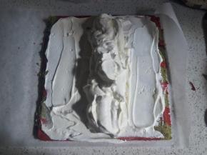 晾凉的蛋糕左右两边斜着45度角切掉一部分蛋糕边，为了方便卷起来能无缝，抹上淡奶油，中间部分的奶油多堆一些呈椭圆