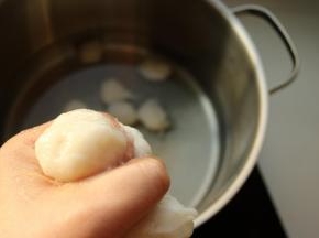 锅里加冷水，用虎口和一个勺子辅助开始挤鱼丸，挤出来之后，用勺子刮下来，放入冷水锅里晃动一下，鱼丸就脱落了。