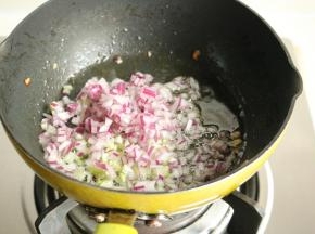 接下来开始做咖喱鱼丸。平底锅放色拉油，下入洋葱末和葱末爆出香味。