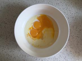 蛋黄内倒入玉米油、牛奶，用蛋抽搅打均匀