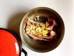 将羊排放入盆中，放入姜丝、蒜瓣
