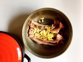 将羊排放入盆中，放入姜丝、蒜瓣
