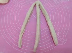 取出一个面团，揉长，切成三份，最上面不切断。