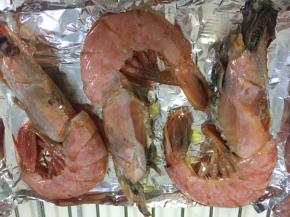 腌好的大虾平铺在锡纸上，表面刷一层植物油