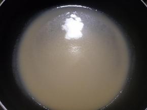 将面糊舀一勺放入平底锅，转动锅子使面糊摊开呈圆形。