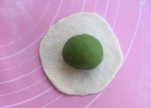 取原色面团擀开，包紧绿色面团