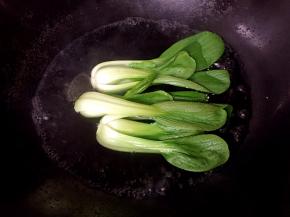 将青菜焯熟，加入适量盐和油防止变色。
