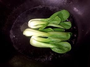 将青菜焯熟，加入适量盐和油防止变色。