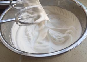 蛋白开始打发，细砂糖分三次加入。快打发好时加入淀粉，打发到起大弯钩。