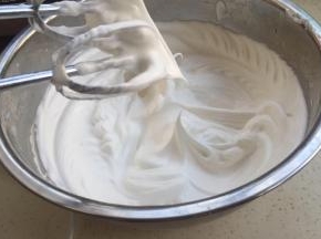 蛋白开始打发，细砂糖分三次加入。快打发好时加入淀粉，打发到起大弯钩。