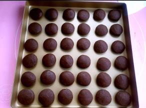 用两手手心稍稍压扁。一次放入烤盘