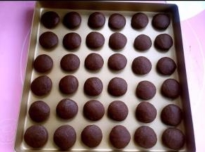 用两手手心稍稍压扁。一次放入烤盘