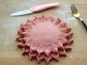 面皮的周围抹上少许清水、把另一个面皮放在上面、轻轻按压一下