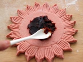 用勺子挖出豆沙、均匀涂抹在做好的面皮上