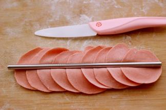 摁扁后用擀面杖擀成圆形薄皮、用筷子在面皮的中间死劲压一下