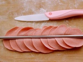 摁扁后用擀面杖擀成圆形薄皮、用筷子在面皮的中间死劲压一下