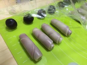 从牛舌状面团的一头卷起，盖上保鲜膜松弛15分钟