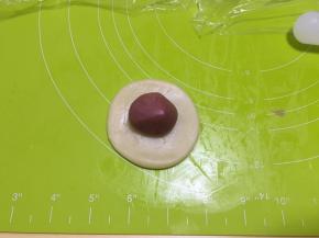 取一个水油皮按扁，擀圆，包入一个油酥