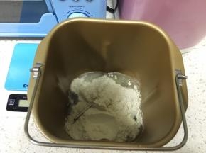 面包机桶取出，先来做水油皮，清水和猪油先倒入面包机桶，倒入中筋面粉，倒入细砂糖，开启和面程序