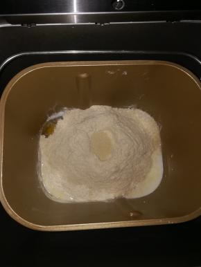 除黄油以后。剩下的材料按照先液体后粉类放入面包机中，中间弄个小坑放入酵母。启动和面程序1次。