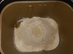 除黄油以后。剩下的材料按照先液体后粉类放入面包机中，中间弄个小坑放入酵母。启动和面程序1次。