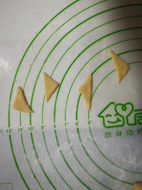 取一点面团，擀好，切成小三角形当耳朵。剩下的搓成长条当尾巴。