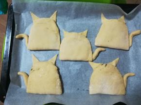 如图。耳朵部分放在上方，用点水粘合。尾巴放在下面。放入烤盘继续发酵30—40分钟。