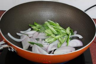 把锅洗净，热锅，倒油，放入洋葱、青椒爆炒；