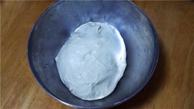 将面粉、酵母放入容器内，加入清水和成面团。我是前天晚上和面，装入保鲜袋放入冰箱冷藏发酵。