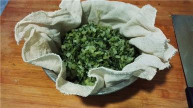 将菜放入屉布中，挤出水分。