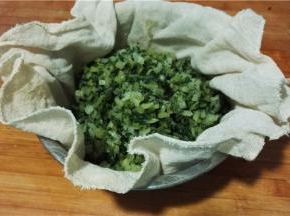 将菜放入屉布中，挤出水分。