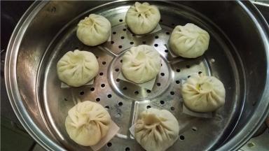 包子下面垫上油纸（屉布）。冬天温度低可以先将蒸锅水加热，然后关火，将包子放入发酵。